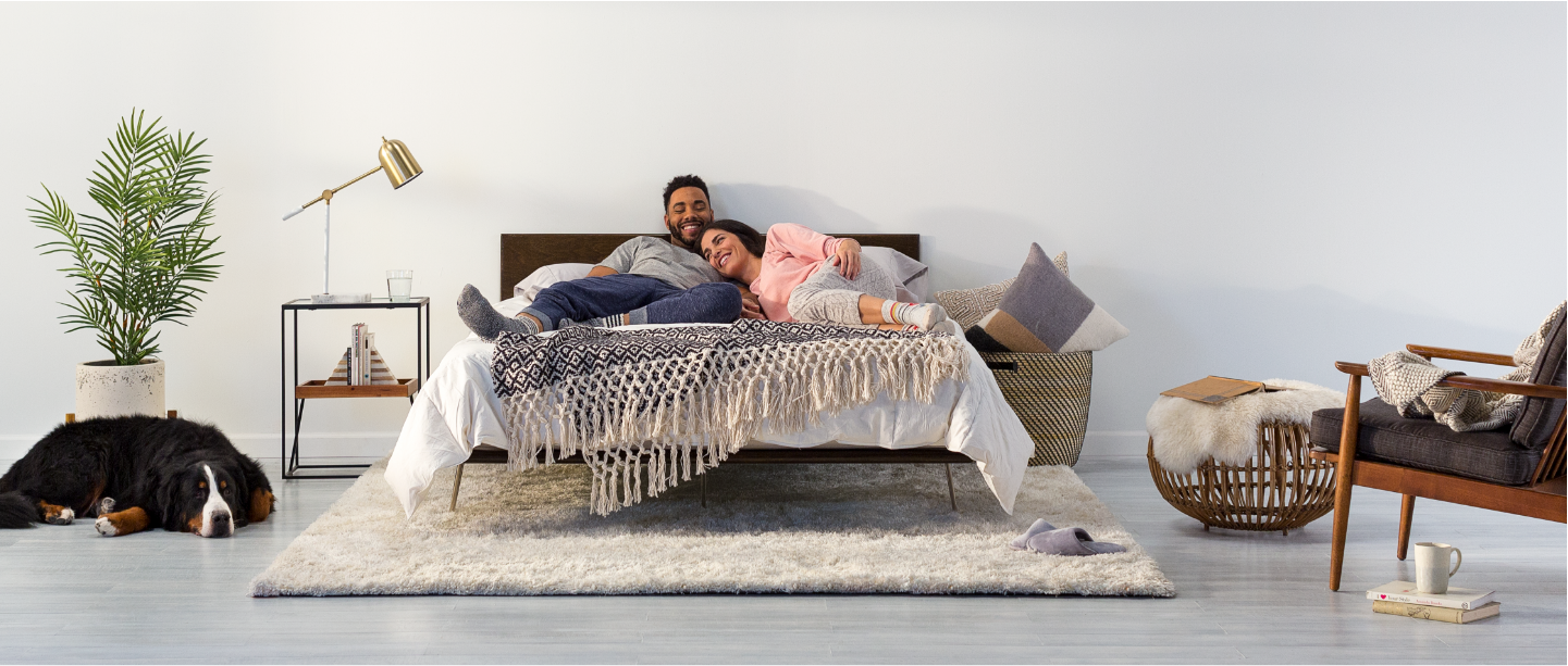 Couple laying on their Tuft and Needle mattress